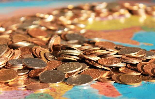 coins sread out on a map of the world